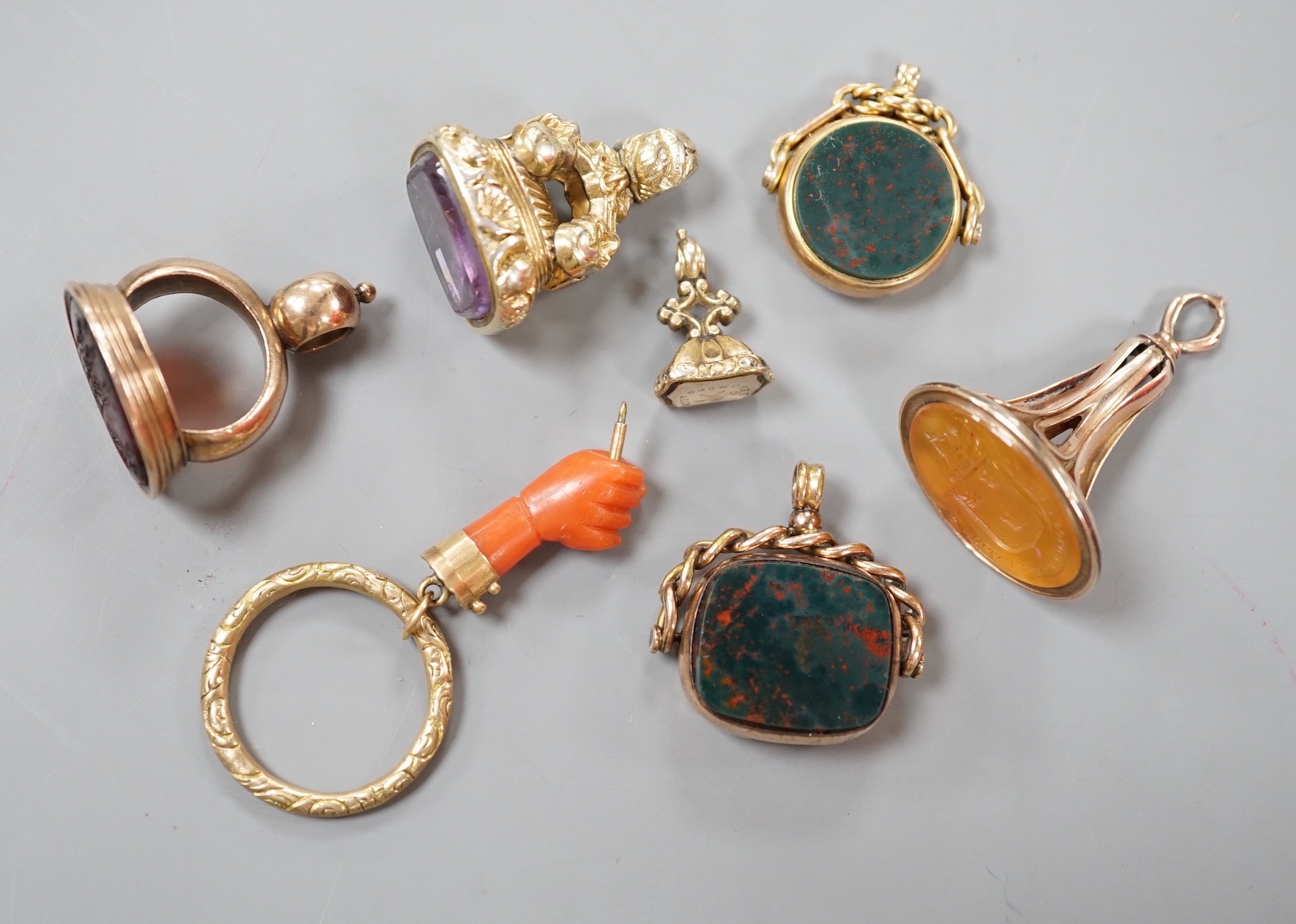 Six assorted late 19th/early 20th century gem set fob seals, including yellow metal overlaid with red intaglio stone carved with Roman soldiers, two 9ct gold, carnelian and bloodstone and a carnelian carved with family c